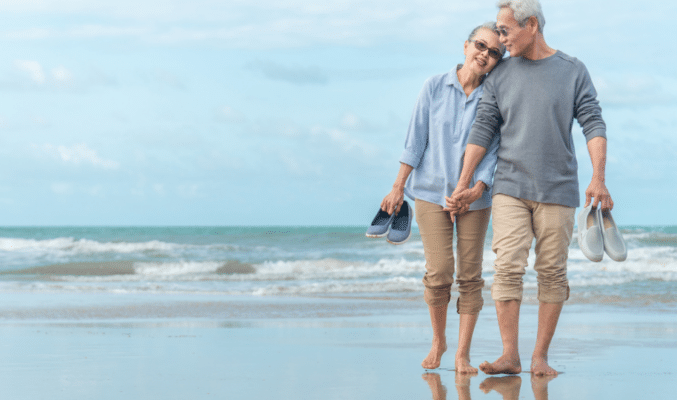 Older couple walking on beach