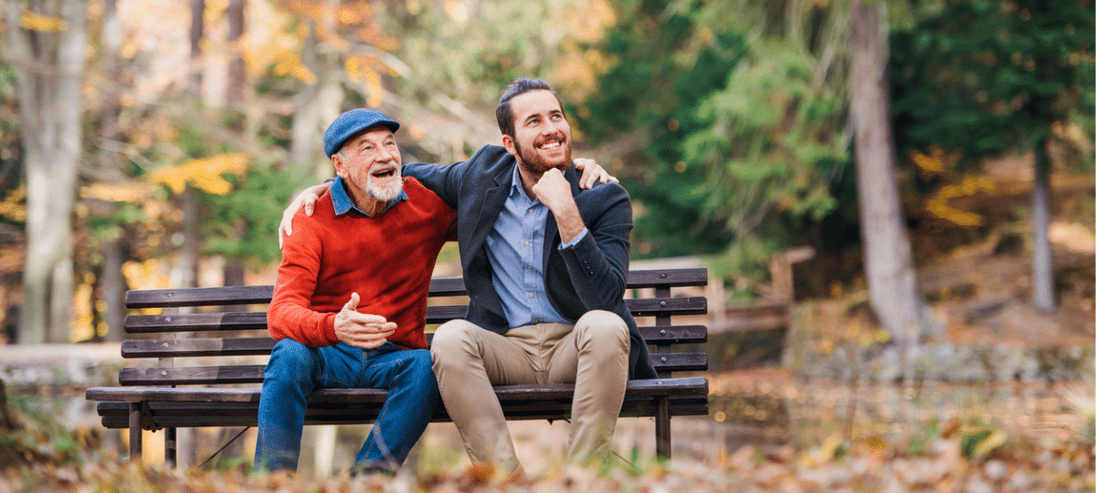 Father & son sitting on bench in Autumn