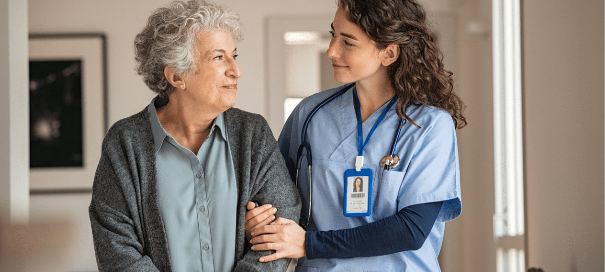 Older woman walking with nurse