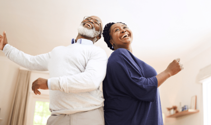 Senior couple dancing in living room